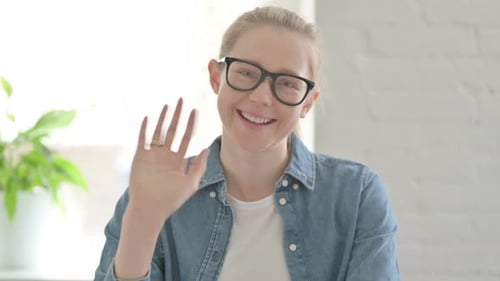 Junge Frau winkt mit der Hand, um Hallo zu sagen
