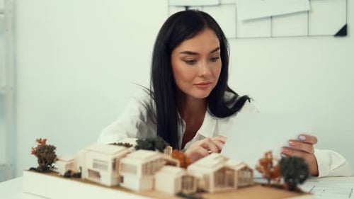Closeup of beautiful architect measure the architectural model. Immaculate.