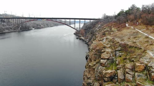 Aerial shot of the beautiful cliffs and bridge with a huge dam on the background, 4k