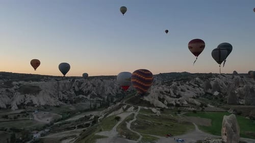 Breathtaking Hot Air Balloons Floating in Valley at Sunrise