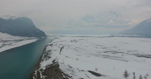 Aerial view of snowy mountains and river in winter, Pakistan.