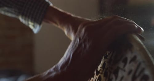 Close up of a carpenter while he is polishing a wooden trunk after he finished to cut it. Concept: