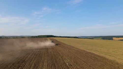 Aerial View of Tractor Plowing Agriculural Farm Field Preparing Soil for Seeding in Summer