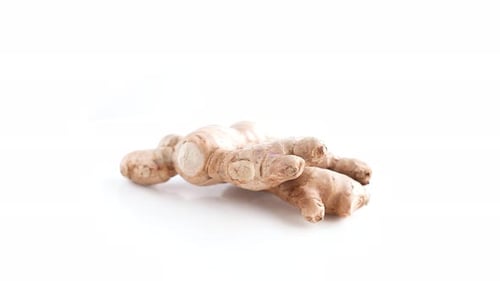 Top shot a hand of ginger and slices rotating 360 degrees on a white background top shot