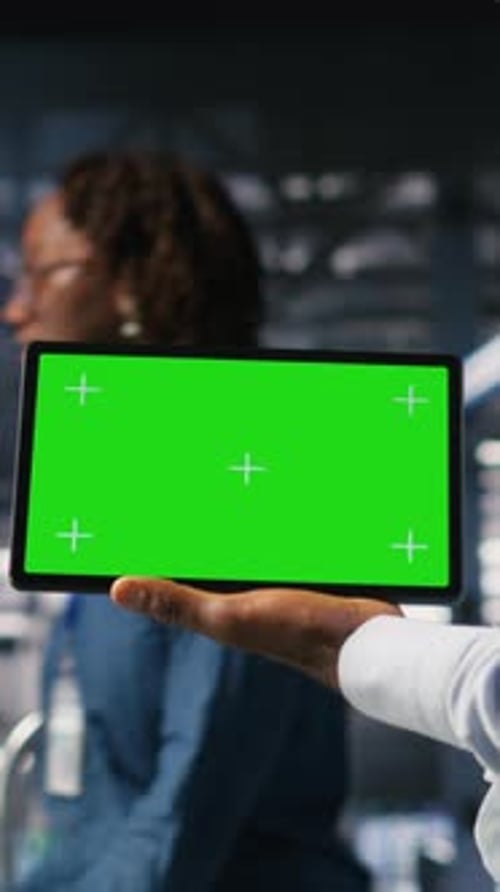 Vertical Video Close Up of Engineer Using Green Screen Mockup Tablet in Data Center