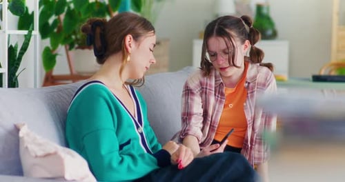 Hija triste le muestra a su madre un smartphone con comentarios ofensivos