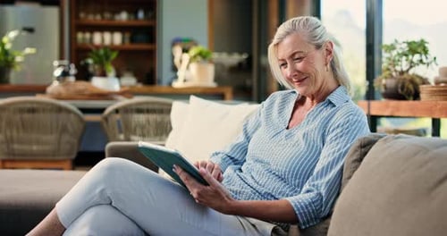 Senior Woman Relaxing on Sofa with Tablet Device