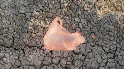 Una bolsa de plástico vuela en tierra seca: desastre ambiental