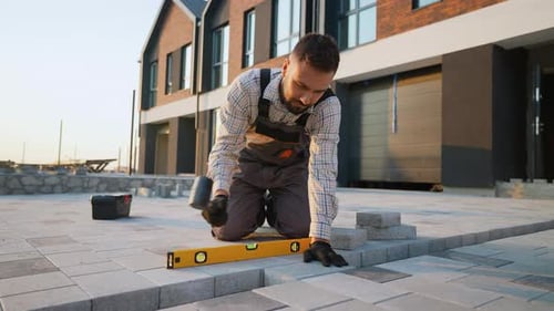 Man Levels Pavers on Driveway Construction Project