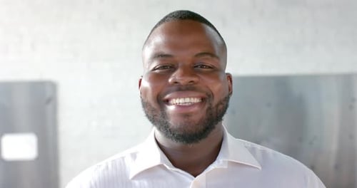 Portrait of happy african american casual businessman with beard smiling in office, slow motion