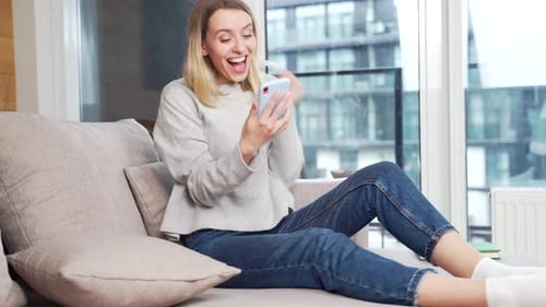 Woman Reacts Happily to Mobile Phone News