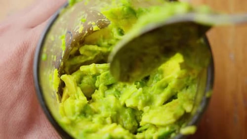 Mixing Mashing Avocado Puree In Glass With Spoon, Close Up