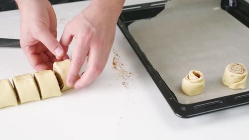male hands making cinnamon rolls