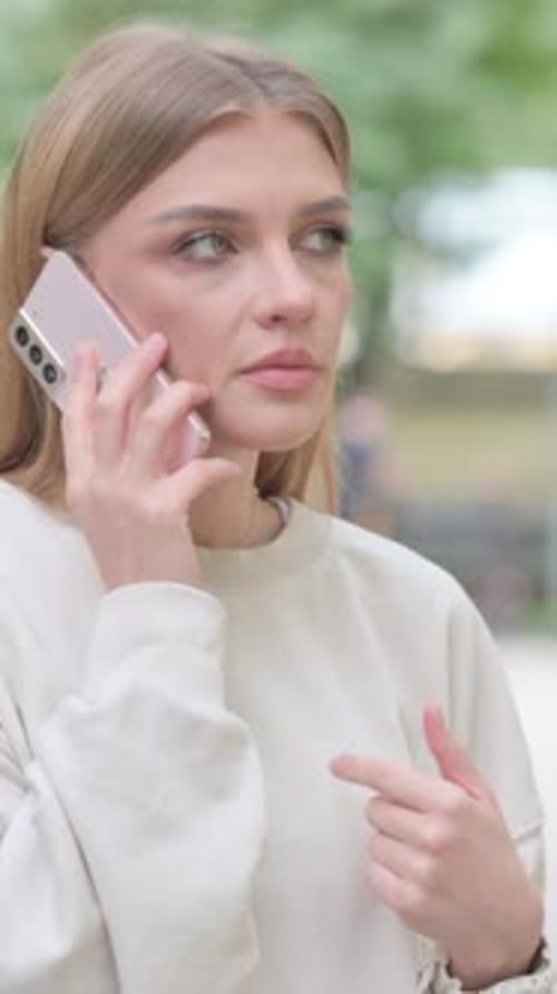 Woman Talks on Mobile Phone Outdoors in Urban Setting