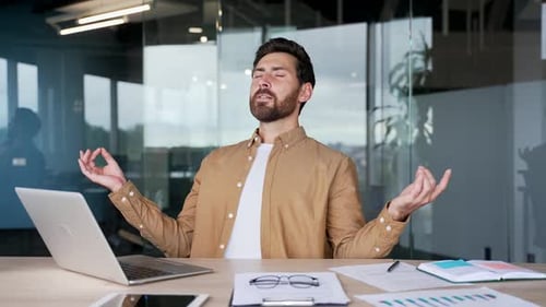 Man Meditating at Desk in Modern Office