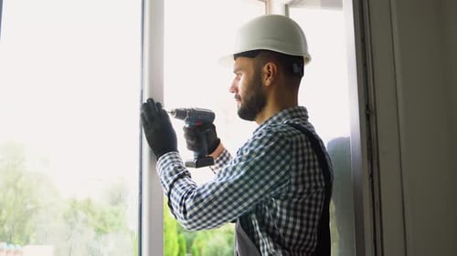 Man Repairing Window Frame with Power Drill