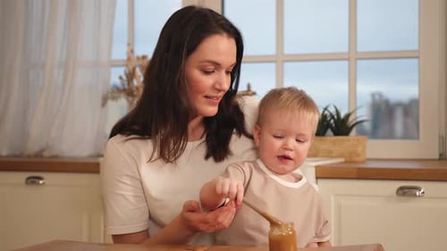 Woman Helping Toddler With Baby Food