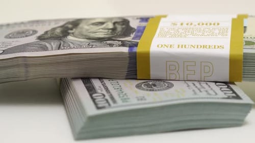Stack of Bank Bundles with US Dollars on a White Background Closeup Shot of New Freshly Printed