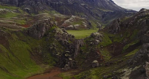 Drone shot revealing a small valley on a moss covered hiking trail in the volcanic mountains of Icel