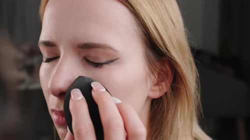 Woman Applies Makeup with Sponge, Close Up