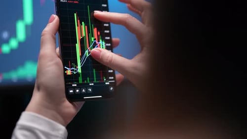 Back View Tracking Shot of Unrecognizable Female Trader Holding Smartphone Doing Stock Market Data