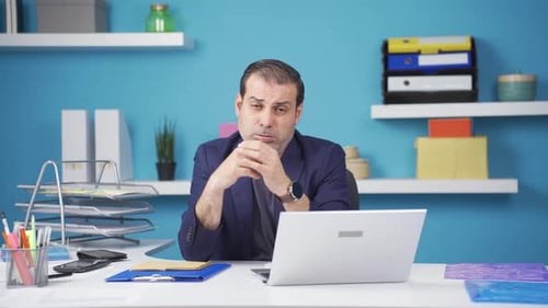 Worried Man at Desk in Office Looking Frustrated
