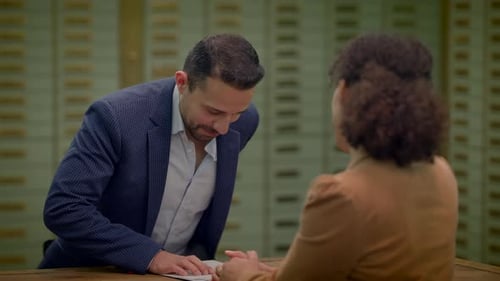 Sales Agent Talking to Customer Inside Safe Vault Room Explaining Deposit