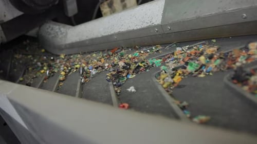 Plastic Pieces Move Along Conveyor Belt for Recycling