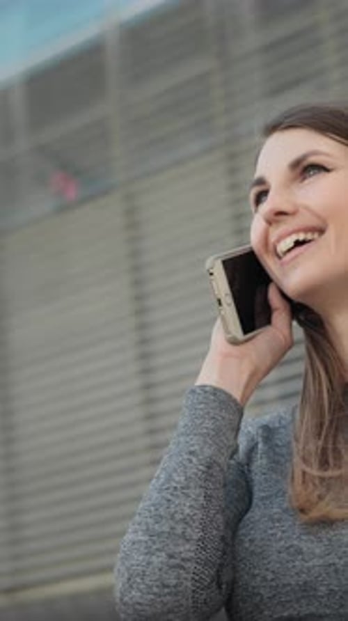 Smiling Woman Using Smartphone in City Setting