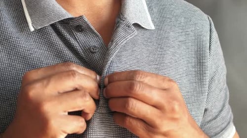 Man Buttoning His Shirt Close Up