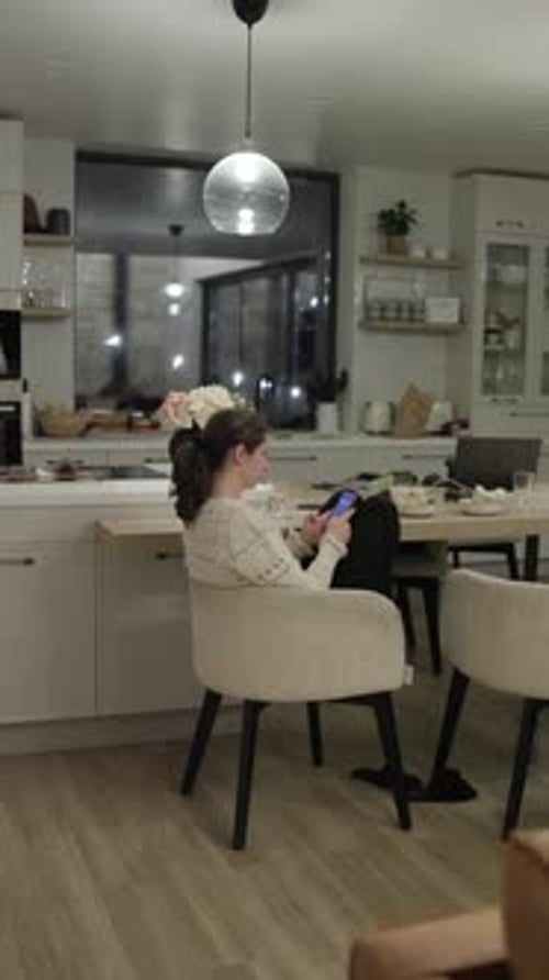 Woman with Dark Hair Sitting in Bright Kitchen