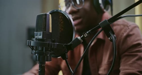 Adult Male Speaker Delivering Clear Dialogue Into Professional Studio Microphone