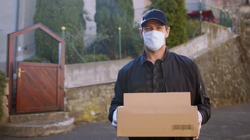 Delivery man wearing face mask delivers parcel boxes in town during pandemic