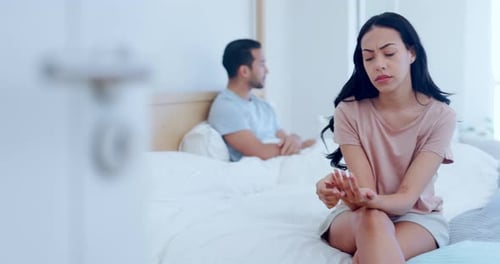 Distressed Couple Sitting Apart on a Bed