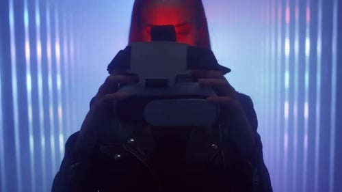The Girl Holds Virtual Reality Glasses in Her Hands Puts Them on Her Head