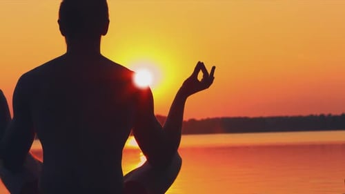 Adult Meditating on the Beach During Sunrise