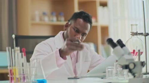 Focused Scientist Working in Lab With Microscope