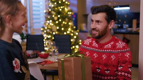 Affectionate Child Hugs Man after Receiving Christmas Gift