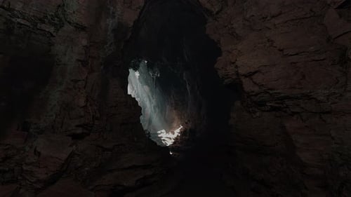 A Mesmerizing Cave with a Ray of Sunlight Streaming Through a Small Opening