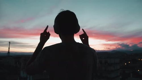 Man Listening to Music at Colorful Sunset