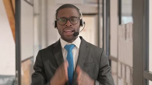 Portrait of African Man with Headset Doing Video Chat in Call Center