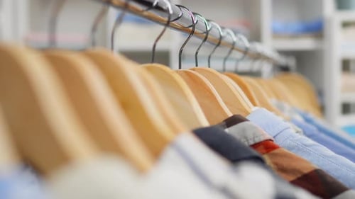 Close Up Of A Clothes Hanger In A Fashion Boutique Clothing Store, Stacked Clothes Shirts Hang
