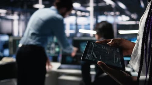 Close Up of Data Center Engineer Using Tablet to Review Code