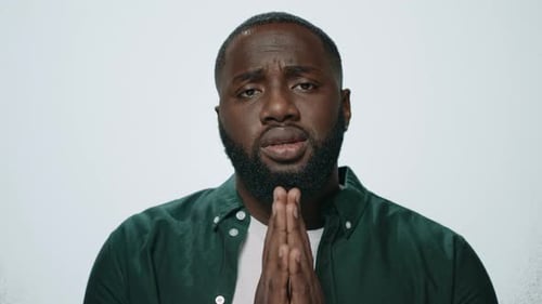 Portrait African American Man Praying in Studio. Serious Guy Holding Hands In