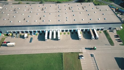 Logistics park with warehouse. Semi-trailers trucks standing on car parking and waiting for loading