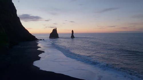 Aerial view of rock formation along the coastline at sunset in Iceland.