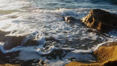 A golden orange color on the rocks during a golden hour evening on the coastline.