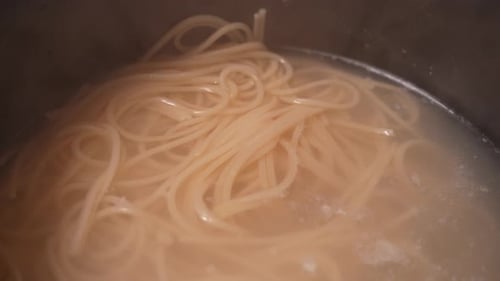 Spaghetti Noodles Boiling in Metal Pot Close Up