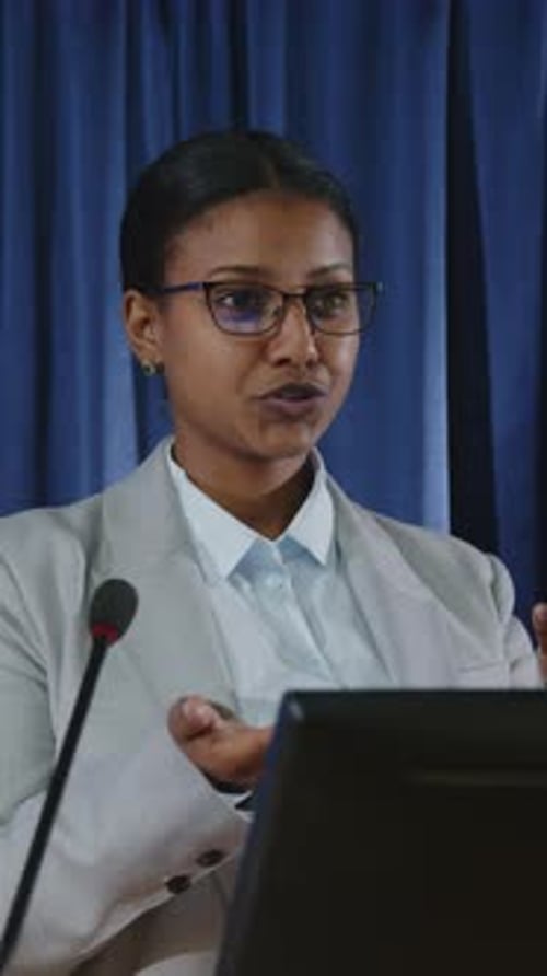 Woman Gives Corporate Speech at a Lectern
