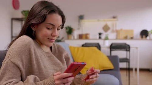 Woman Using Smartphone with Credit Card at Home